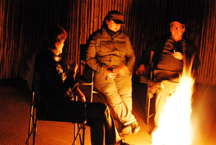 After the Evening Game Drive, Guests Sit Around the Campfire Talking About the Day's Activities.