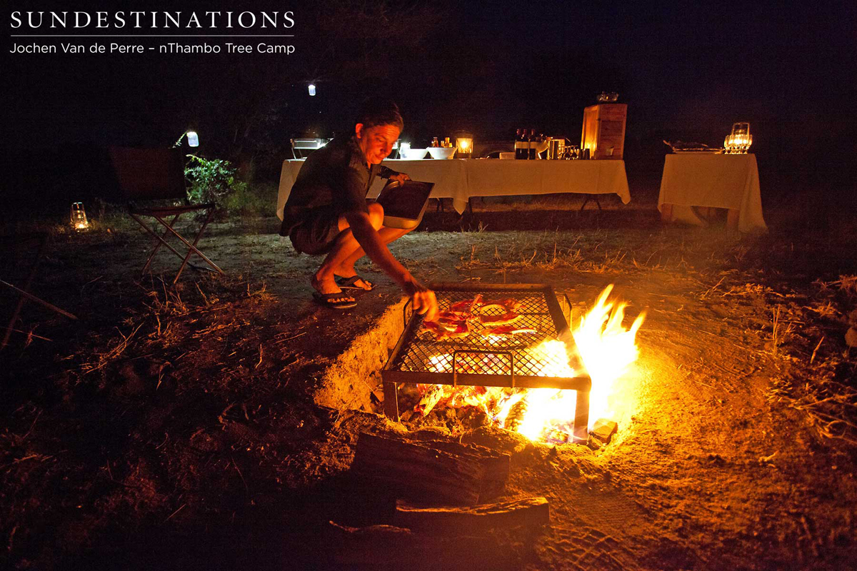 Hennie stacking the coals and arranging the meat on the braai
