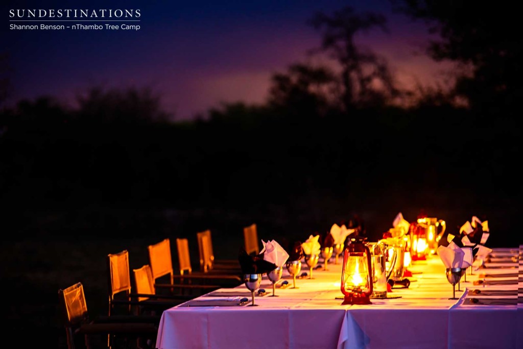 Seating around a lantern-lit table in the bush